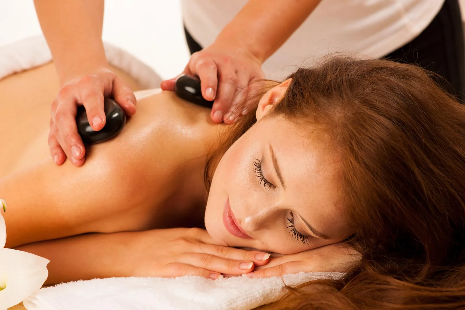Stein-Therapie. Frau erhält eine Hot-Stone-Massage im Wellness-Salon
