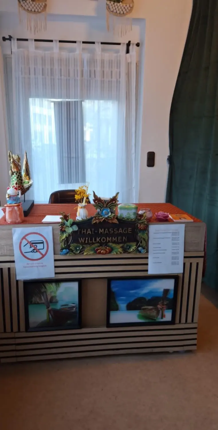 Ruai Thong Thai Massage - Begrüßung an der Rezeption, Bilderrahmen und Schild „Keine Kartenzahlung