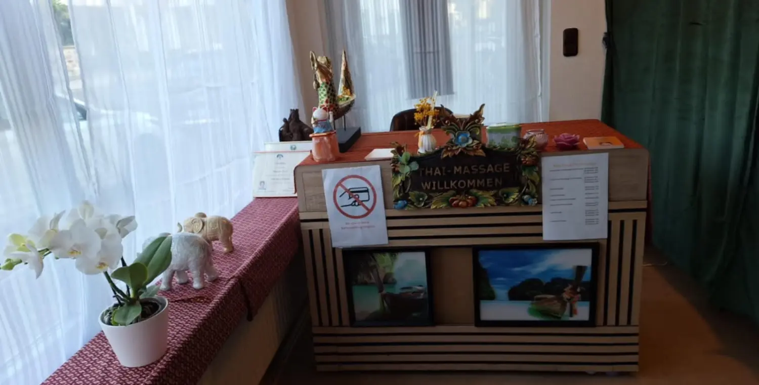 Ruai Thong Thai Massage - Begrüßung an der Rezeption, Bilderrahmen und Schild „Keine Kartenzahlung